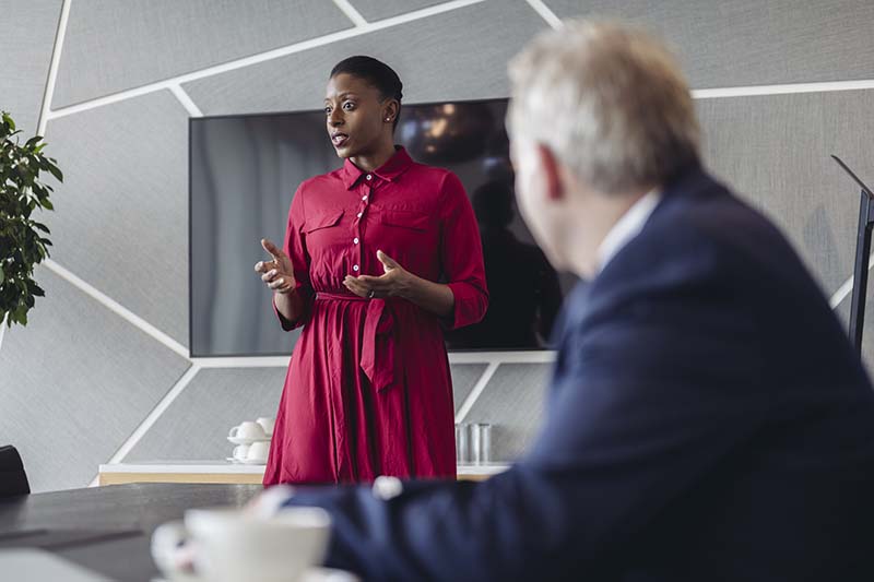 Person presenting next to a screen